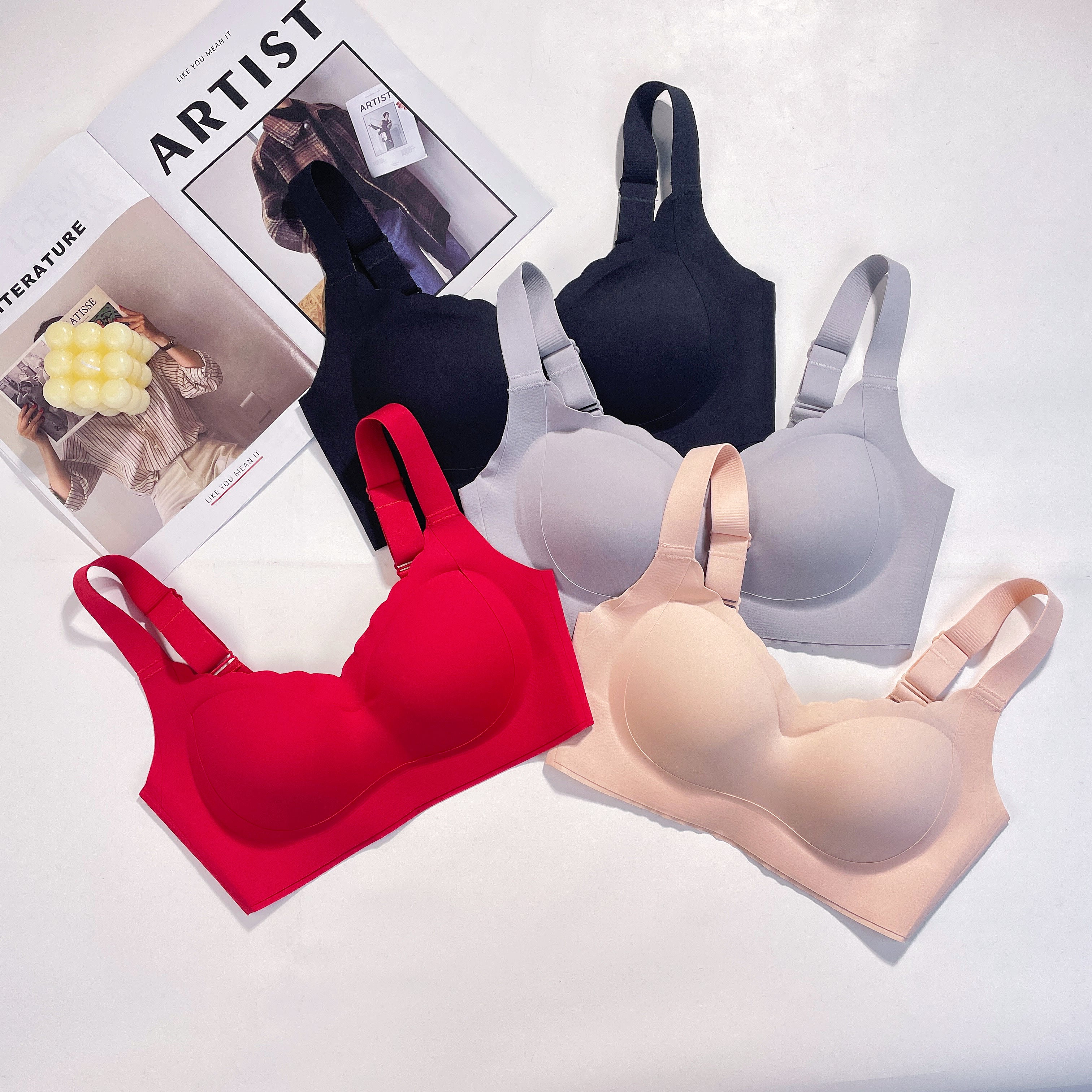 A set of wireless bras in various colors (red, black, beige and gray) arranged on a flat surface.