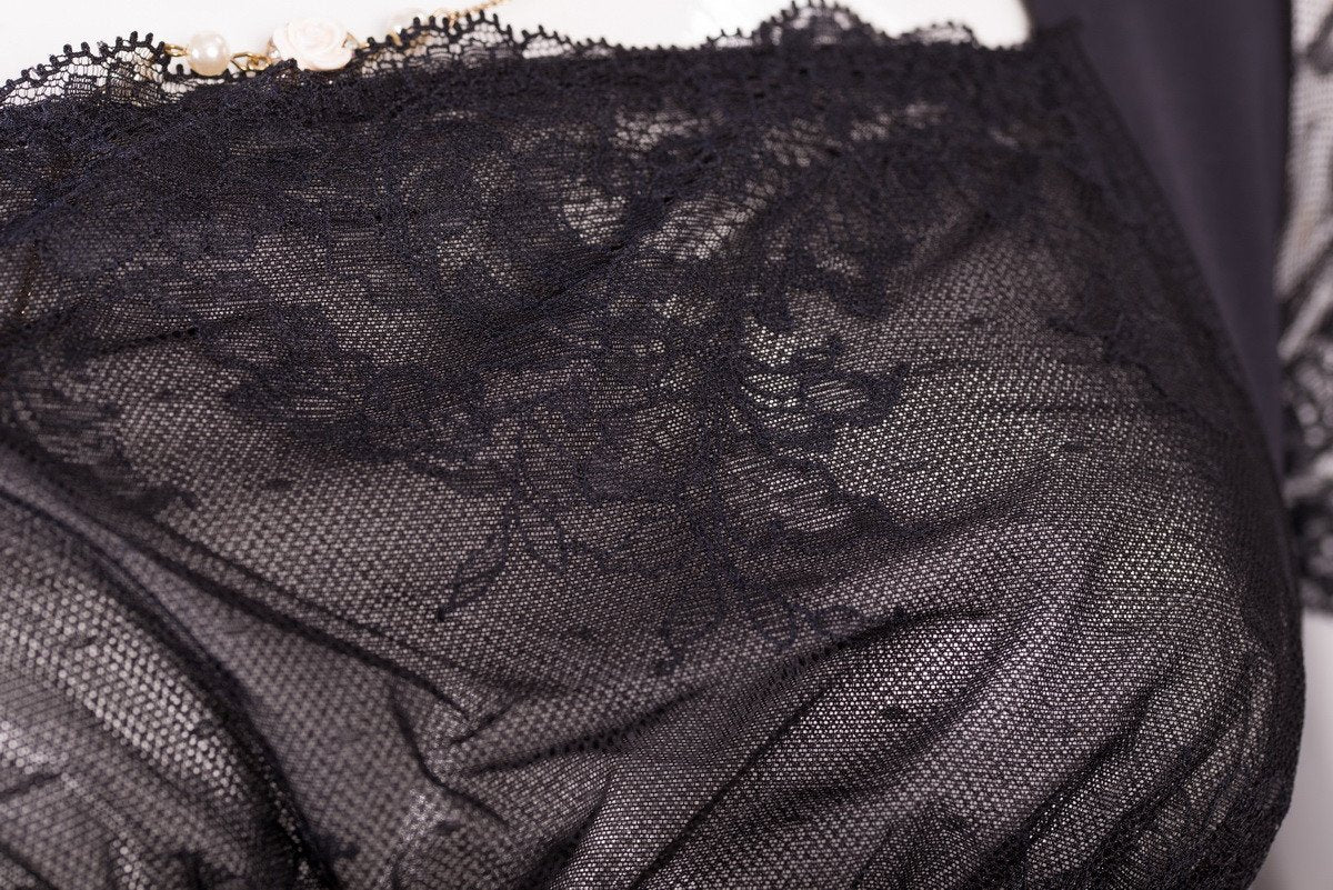 Detail view of black Intelligent Curve lace romper shapewear showing floral lace sleeve design